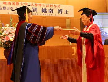 Liu Jinan, Honorary President of Communication University of China (right) is awarded an Honorary Doctorate by Chancellor Noriko Mizuta