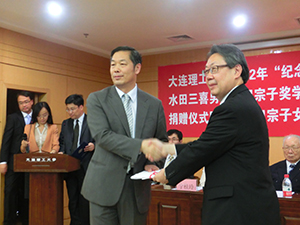 The book donation catalogue being presented to Professor Su Jingqin (L)