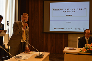 Director Oka during his presentation