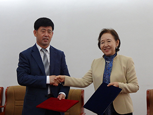 Chancellor Mizuta and President Yang shake hands following the agreement signing
