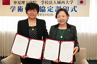 Principal Zhao (L) and Chancellor Mizuta following the signing