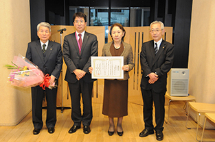 Chancellor Mizuta displays her award from the JCCI