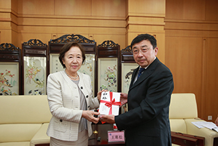 Chancellor Mizuta holding the special hardcover edition of Kiro