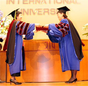 Sun Yu Hua (on the right), President of Dalian University of Foreign Languages, receives an honorary doctorate 
degree.
