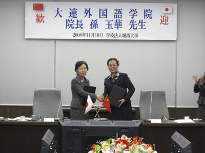 President Song of Dalian University of Foreign Languages and Chancellor Mizuta shake hands after concluding agreement.