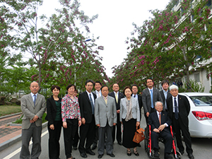 Commemorative photo with representatives from both universities in the red acacia grove