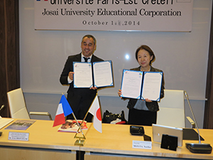 Mr. Hertzler (left) and Chancellor Mizuta appose their seals to the exchange agreement