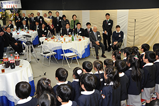 かぴら幼稚園の園児の合唱に聞き入る水田理事長ら